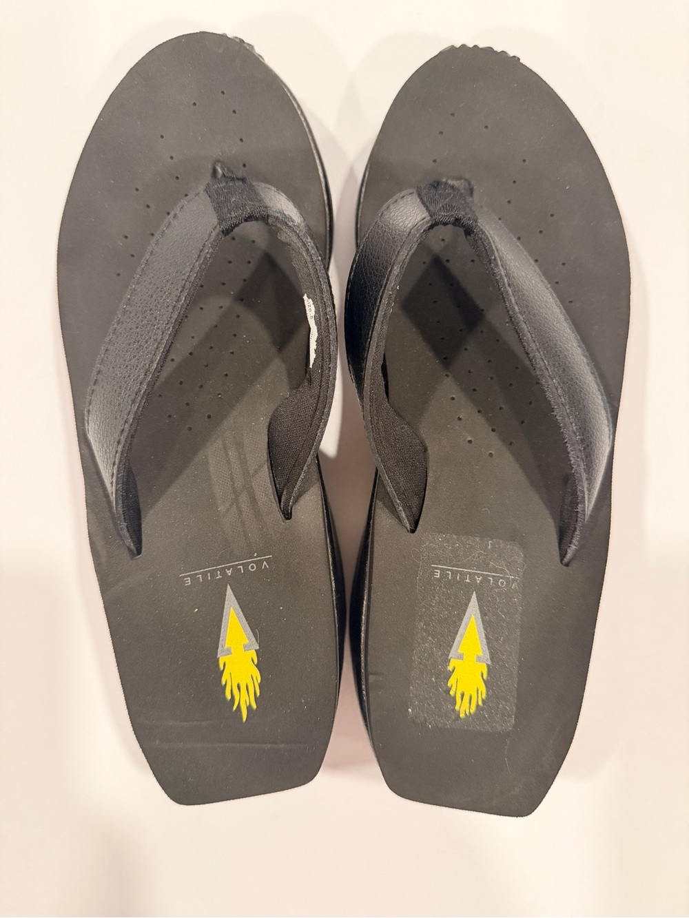 Volatile Women Black Flip Flops with Yellow Logo Accent